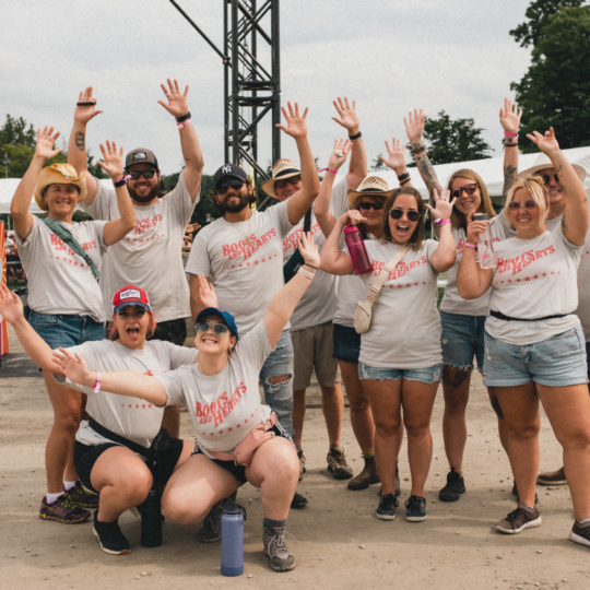 Group of volunteers at the festival with their hands up