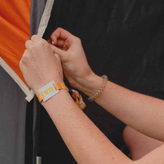 Fan setting up tent with wristband on